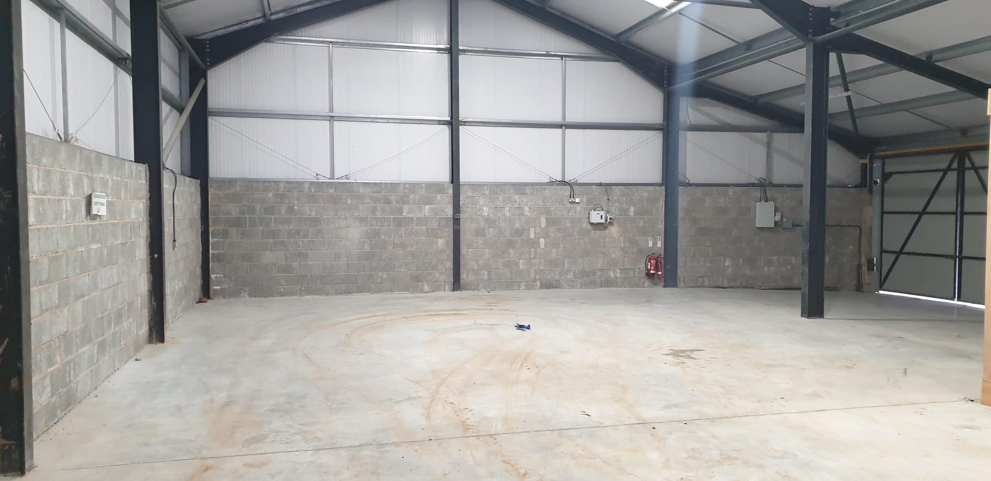 Warehouse interior looking towards roller shutter entrance with forklift
